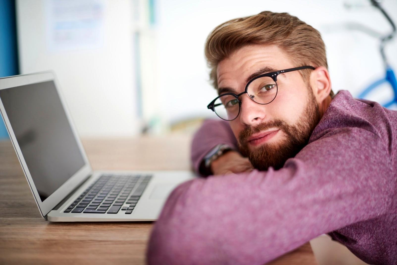 Programmatore che inizia carriera con laptop e documentazione tecnica